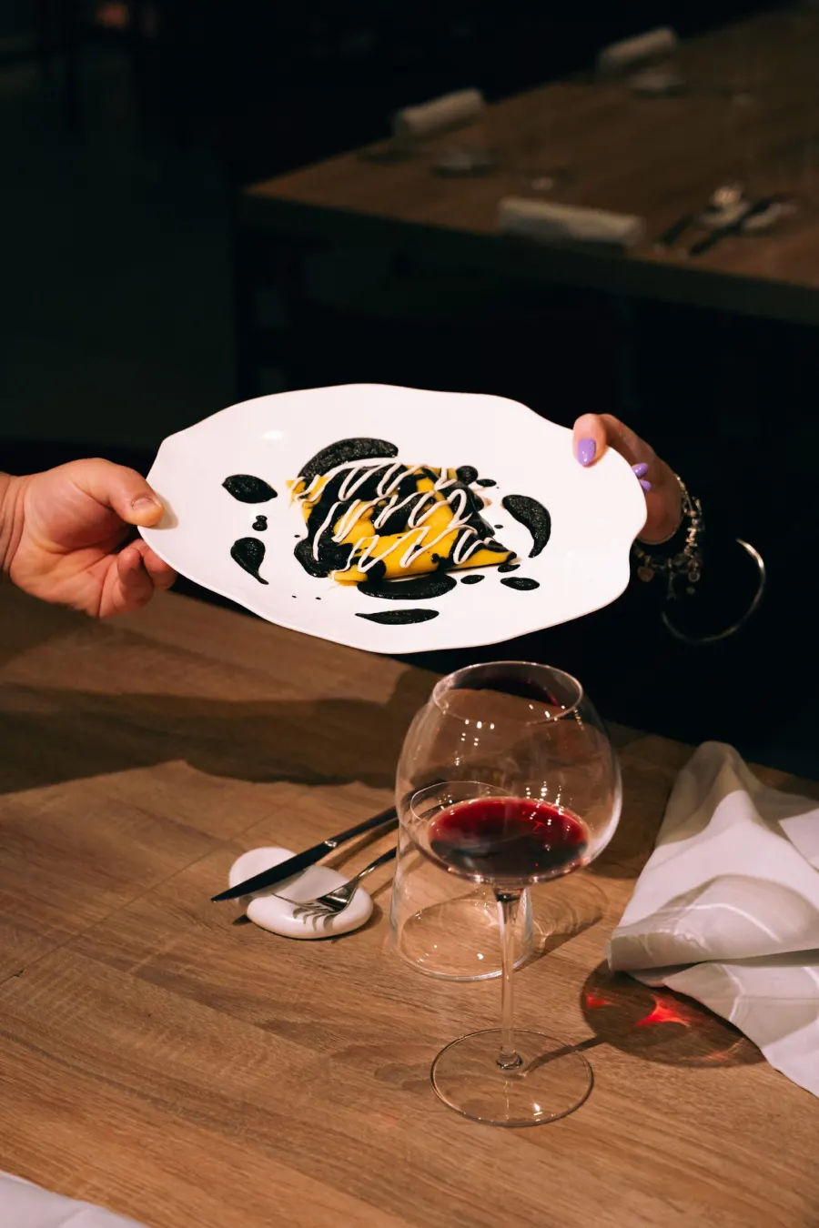 Un piatto servito al tavolo con un calice di vino